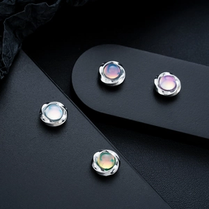 Detailed macro view of silver Mobius earrings with iridescent cat eye stones on display