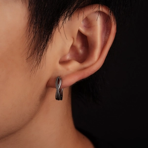Close-up of vintage silver twisted rope hoop earring featuring textured metal details