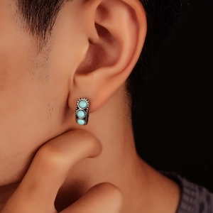 Close-up of vintage hoop earrings with turquoise inlay on male model's ear