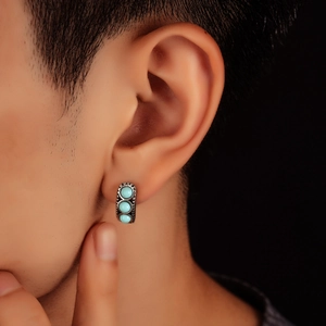 Vintage silver-tone hoop earring with three turquoise stones on male model ear