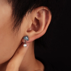 Vintage lotus stud earrings with white pearl pendant shown on model in a macro view