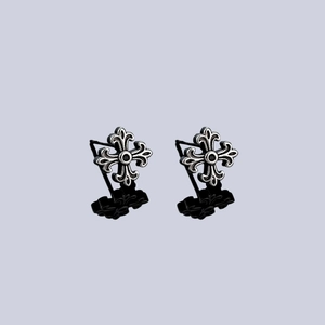 Détail macro de boucles d'oreilles croix en argent rétro avec motif fleur de lys