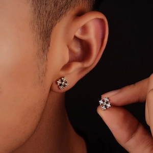 Boucles d'oreilles croix rétro en argent et or portées par un modèle pour hommes et femmes
