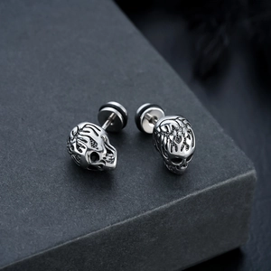 Macro shot of retro skull stud earrings with detailed vintage silver metallic finish