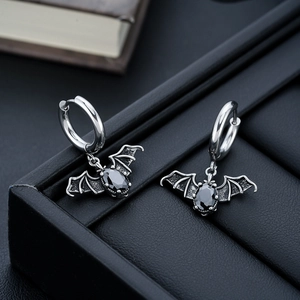 Gothic silver batman earrings with black gemstone pendant on leather gift box edge