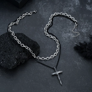 Detail of double-layer necklace with industrial cross pendant and silver link chain