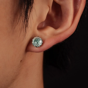 Vue macro d'un clou d'oreille vert menthe avec serti à quatre griffes et coupe de feu
