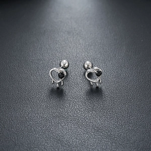 Détail de boucles d'oreilles cœur avec pierres noires et fermoir à vis sur cuir