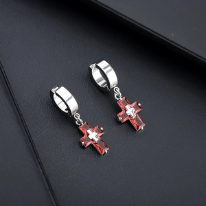 Boucles d'oreilles croix en argent avec zircons rouges sur fond de cuir noir