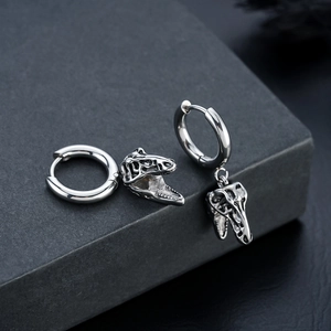 Detailed macro view of retro punk T-Rex skull earrings in oxidized silver steel
