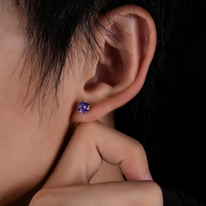 Detail of purple cubic zirconia labret stud earring in a four-prong titanium setting