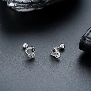 Détail macro des boucles d'oreilles cœur évidé avec pierre noire et fermoir à vis