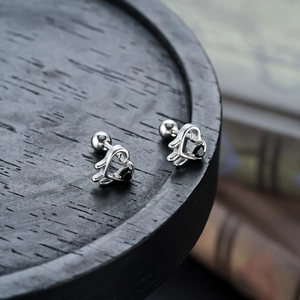 Détail de boucles d'oreilles cœur en argent avec pierre noire et fermoir à vis