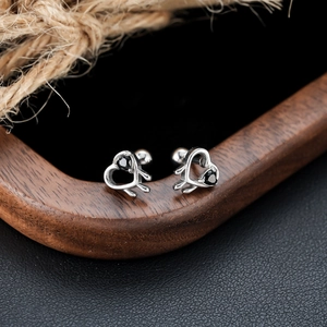 Boucles d'oreilles cœur évidé avec pierre noire et fini argenté sur support en noyer