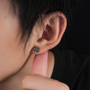 Vintage oxidized silver cross stud earring worn by a model in a close-up profile view