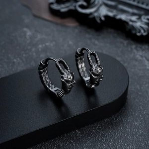 Close-up of retro black feline earrings with intricate woven texture and cat engraving