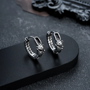 Detailed macro view of vintage silver cat earrings with textured rope band pattern