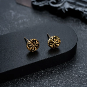 Vintage gold cross relief round stud earrings shown on elegant black geometric display