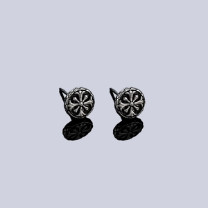 Gothic cross stud earrings in retro silver steel finish shown on reflective surface