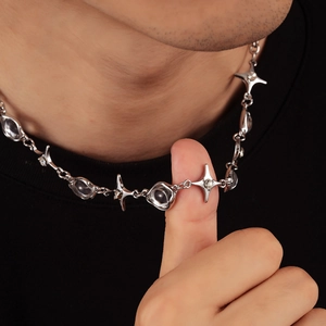 Silver four-pointed star necklace with irregular beads on a model's neck
