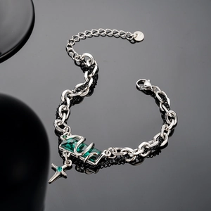 Snake winding around emerald gemstone bracelet with cross pendant in silver finish