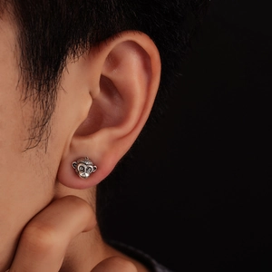 Close-up of silver monkey head magnetic ear cuff on male model with vintage matte finish