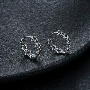 Gros plan de boucles d'oreilles vintage en argent avec texture chaîne tressée