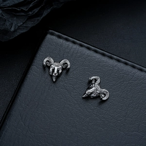 Dettaglio orecchini a testa di ariete punk in argento vintage su pelle nera