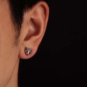 Detailed close-up of a silver zodiac tiger head earring with vintage textured finish