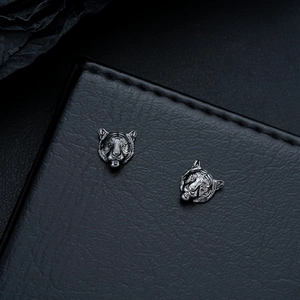 Macro detail of zodiac tiger stud earrings with antique silver finish and carved texture