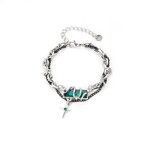 Minimalist double-layer serpent bracelet with green gemstone and cross pendant on white back
