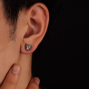 Close-up of vintage tiger head earring featuring detailed silver-toned metal textures