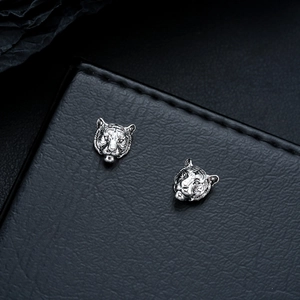 Macro shot of silver tiger head magnetic ear clips with intricate vintage engraving details