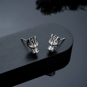 Macro detail of dragon head earring featuring antique silver finish and intricate carving