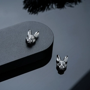Macro shot of silver-gray rabbit magnetic ear clips with realistic fur textures and metallic luster