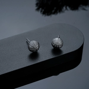 Detailed view of basketball earrings featuring matte black texture and realistic stitching