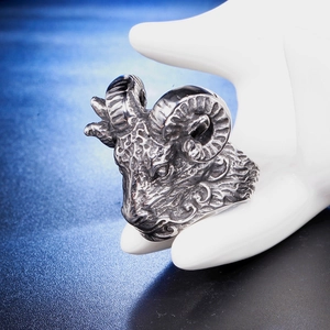 Macro detail of gothic ram skull ring showing intricate vintage steel textures on hand model