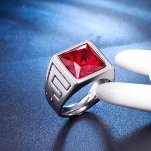 Gros plan d'une bague en acier pour homme avec pierre rouge carrée et motif géométrique