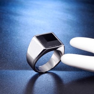 Macro detail of men's wide stainless steel ring with a square black inlaid stone