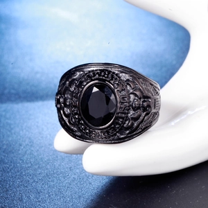 Détail macro du relief d'aigle et de la pierre noire sur une bague vintage en acier