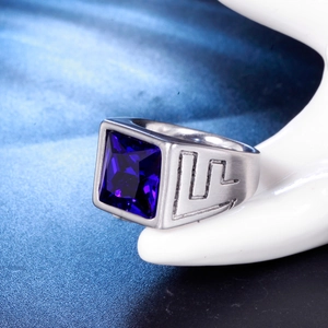 Vue macro d'une bague en titane argenté avec pierre bleue carrée et rainures latérales