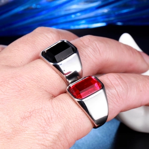 Close-up of stainless steel rings featuring inset red and black rectangular gemstones