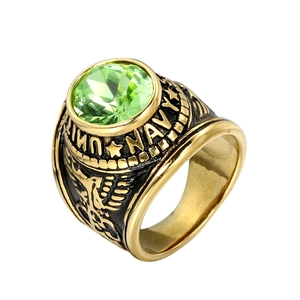 Macro detail of men's gold Navy eagle ring with multifaceted green gemstone top
