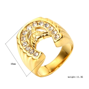 Detailed close-up of a gold-plated horseshoe ring with horse head and cubic zirconia