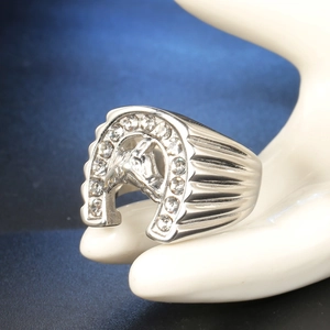 Detail of silver horseshoe ring featuring micro-paved diamonds and embossed horse head