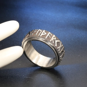 Macro detail of Nordic rune engravings on rotating stainless steel vintage men's ring