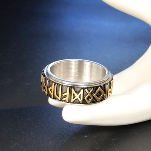 Macro shot of Viking rune spinner ring on hand model with black and gold relief details