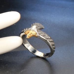 Close-up of vintage punk eagle ring featuring gold eagle head and silver feather textures