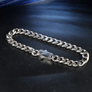 Polished silver stainless steel Cuban link bracelet with rectangular clasp on dark background