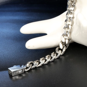 Fashionable stainless steel Cuban link bracelet with freshwater pearls on a ceramic hand display